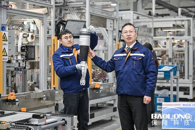 保隆科技副总裁王胜全介绍(右)合肥园区空簧减振工厂产线
